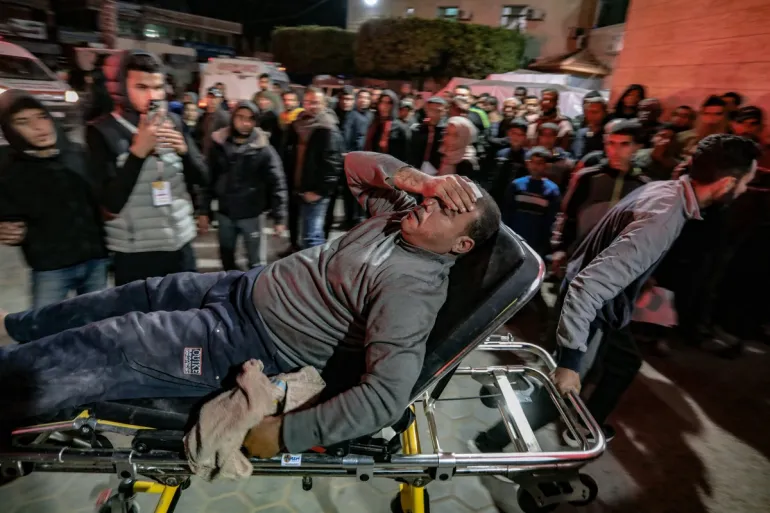 An injured man is rushed to the emergency ward of Al-Aqsa Hospital in Deir el-Balah, on March 1, 2024 [AFP]