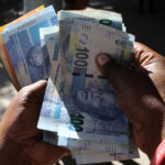 A street money changer counts South African Rands in Harare.