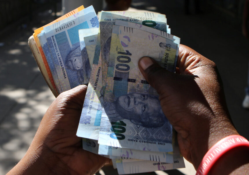 A street money changer counts South African Rands in Harare.